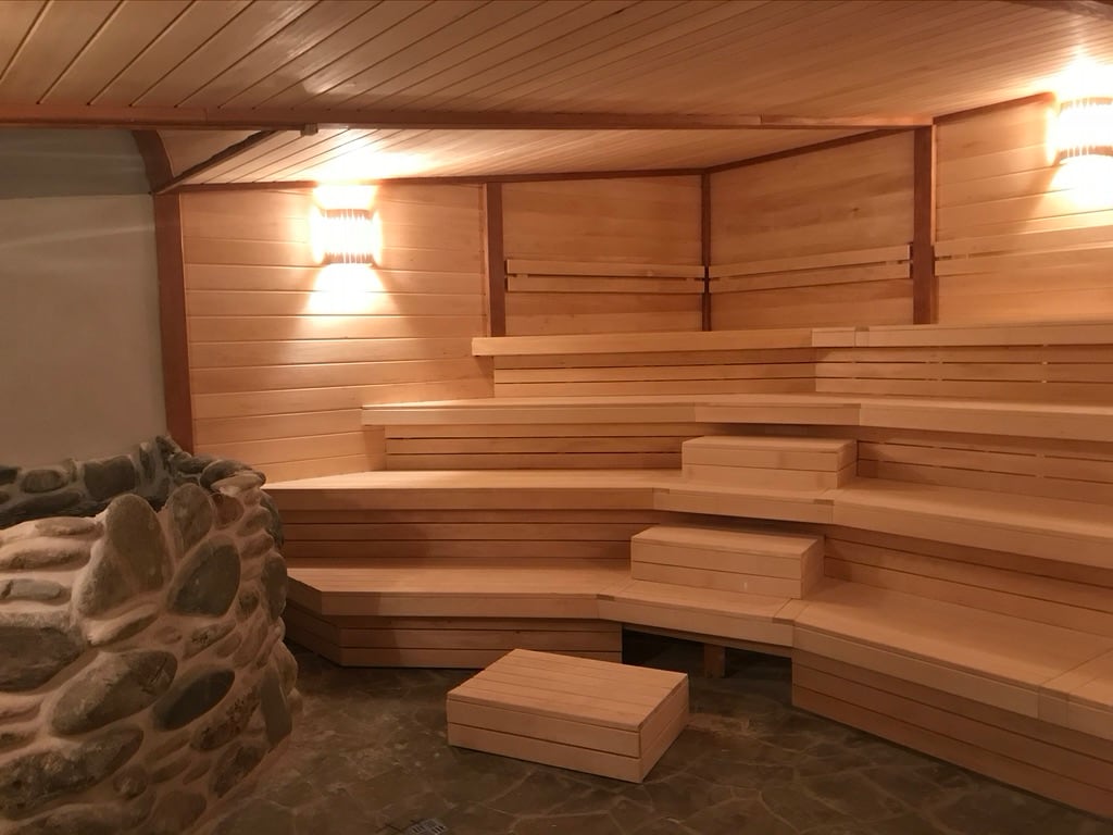 Каменная печь и полки деревянной сауны